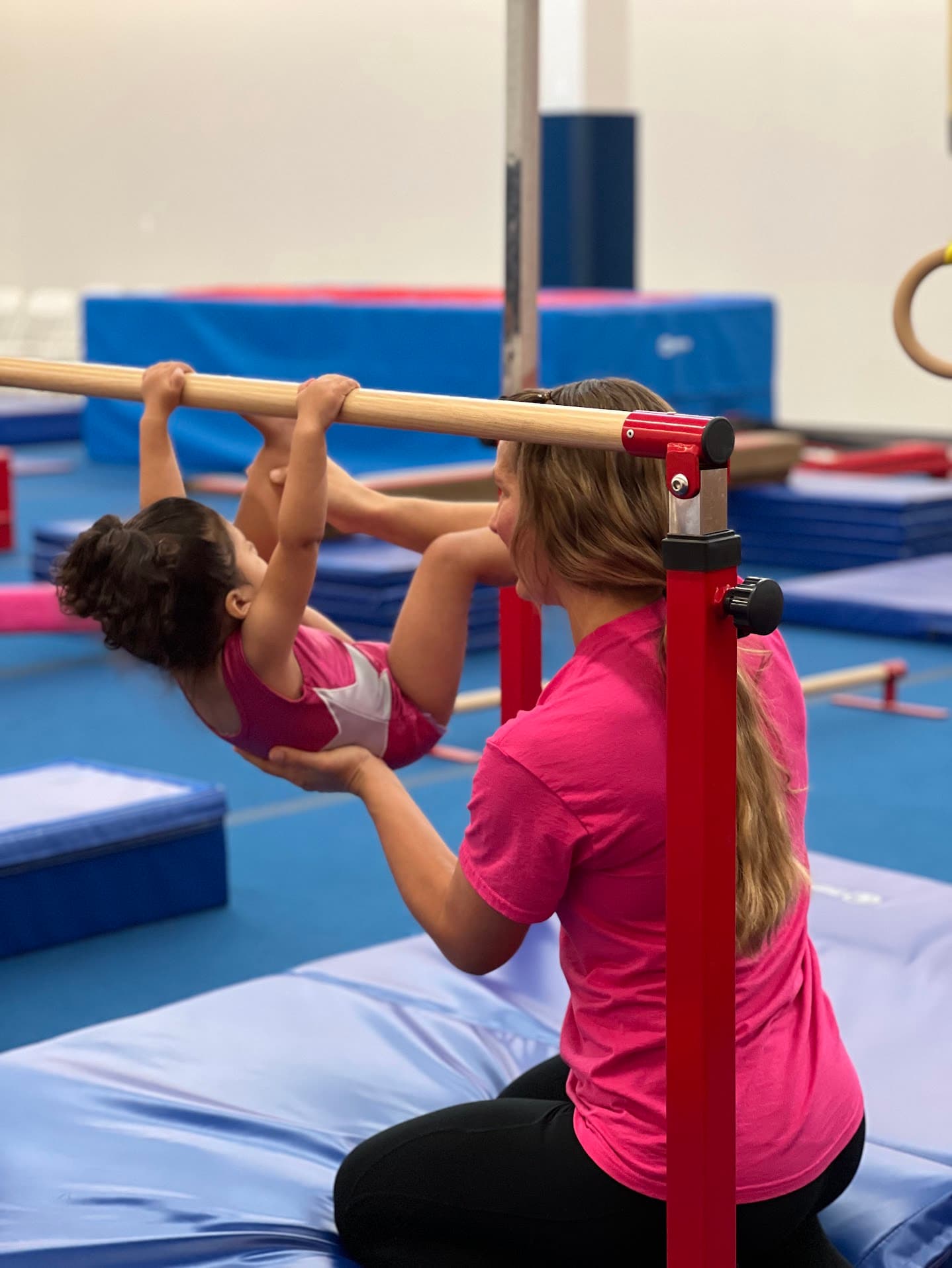 Coach supporting a small girl in a preschool class