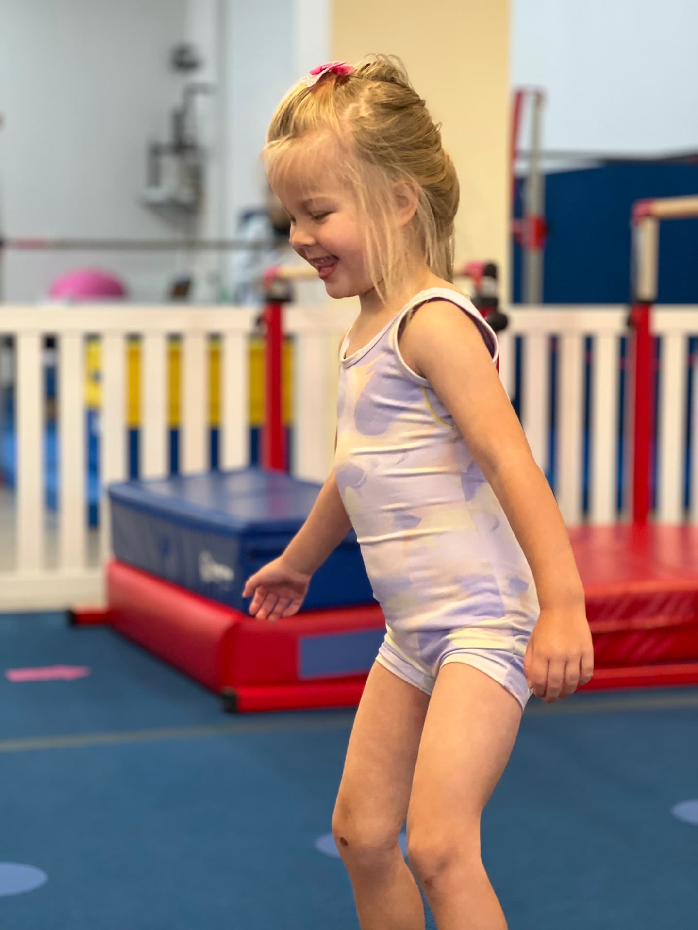 Little girl smiling in a preschool gymnastics class