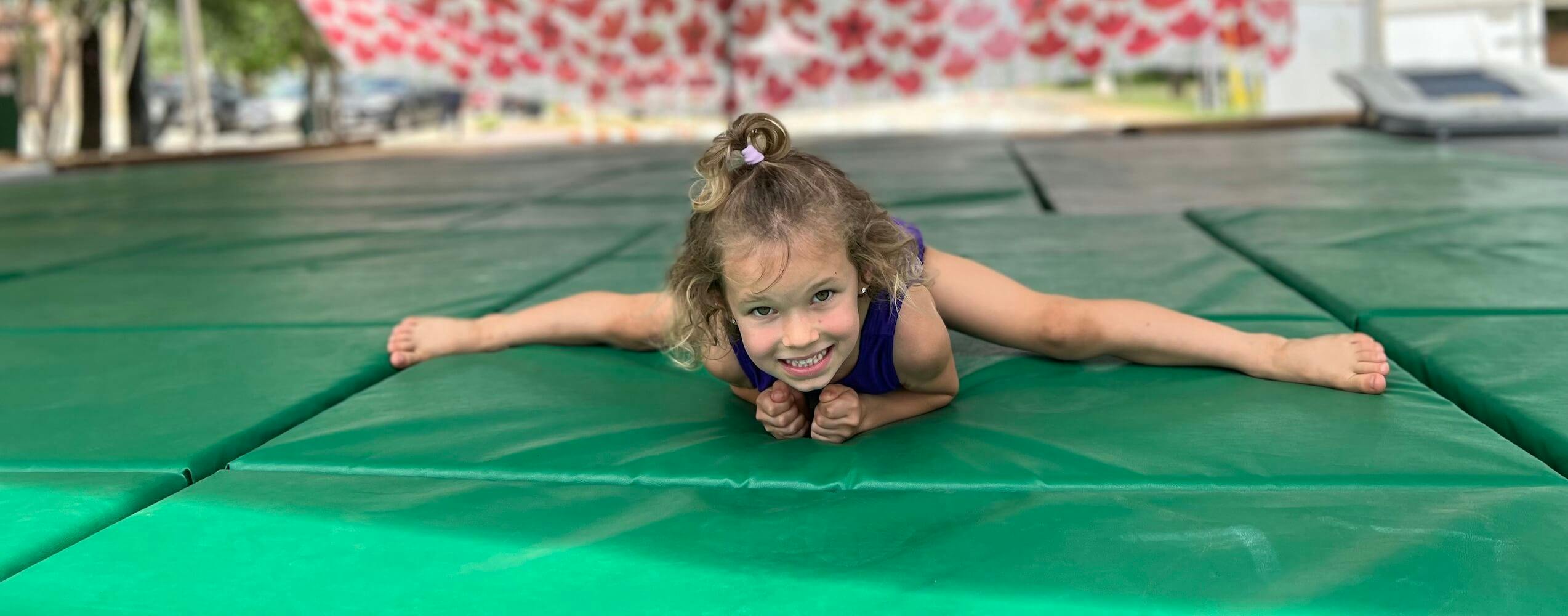 A child smiling on a green mat