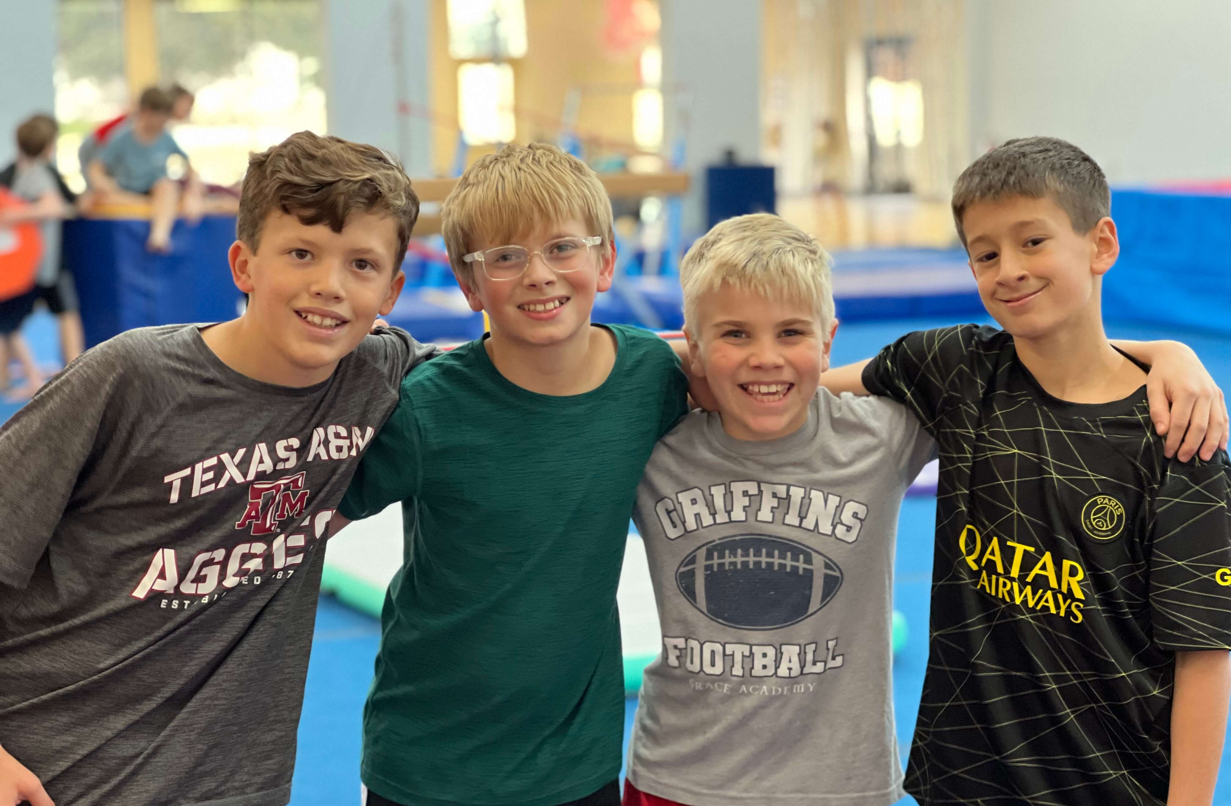 Four campers smiling together in the gym