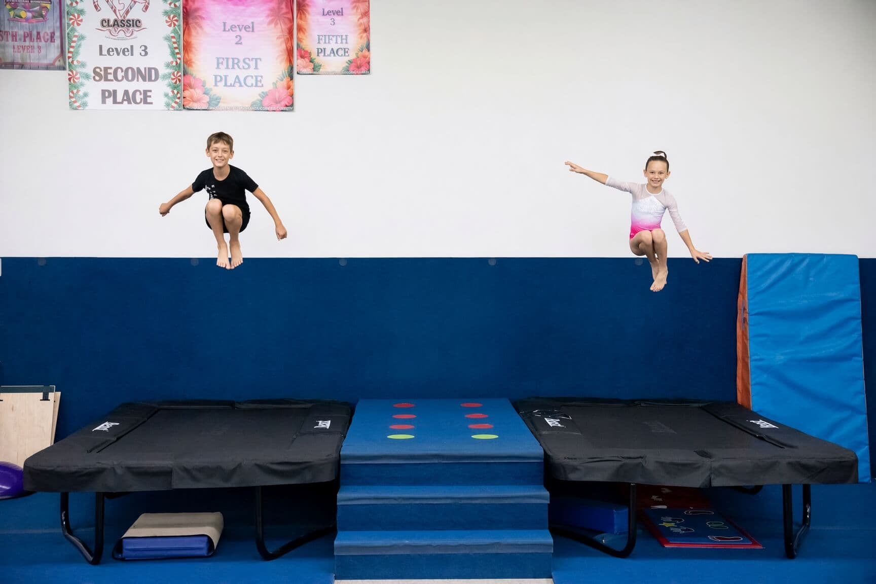 Two kids jumping on trampolines during open gym