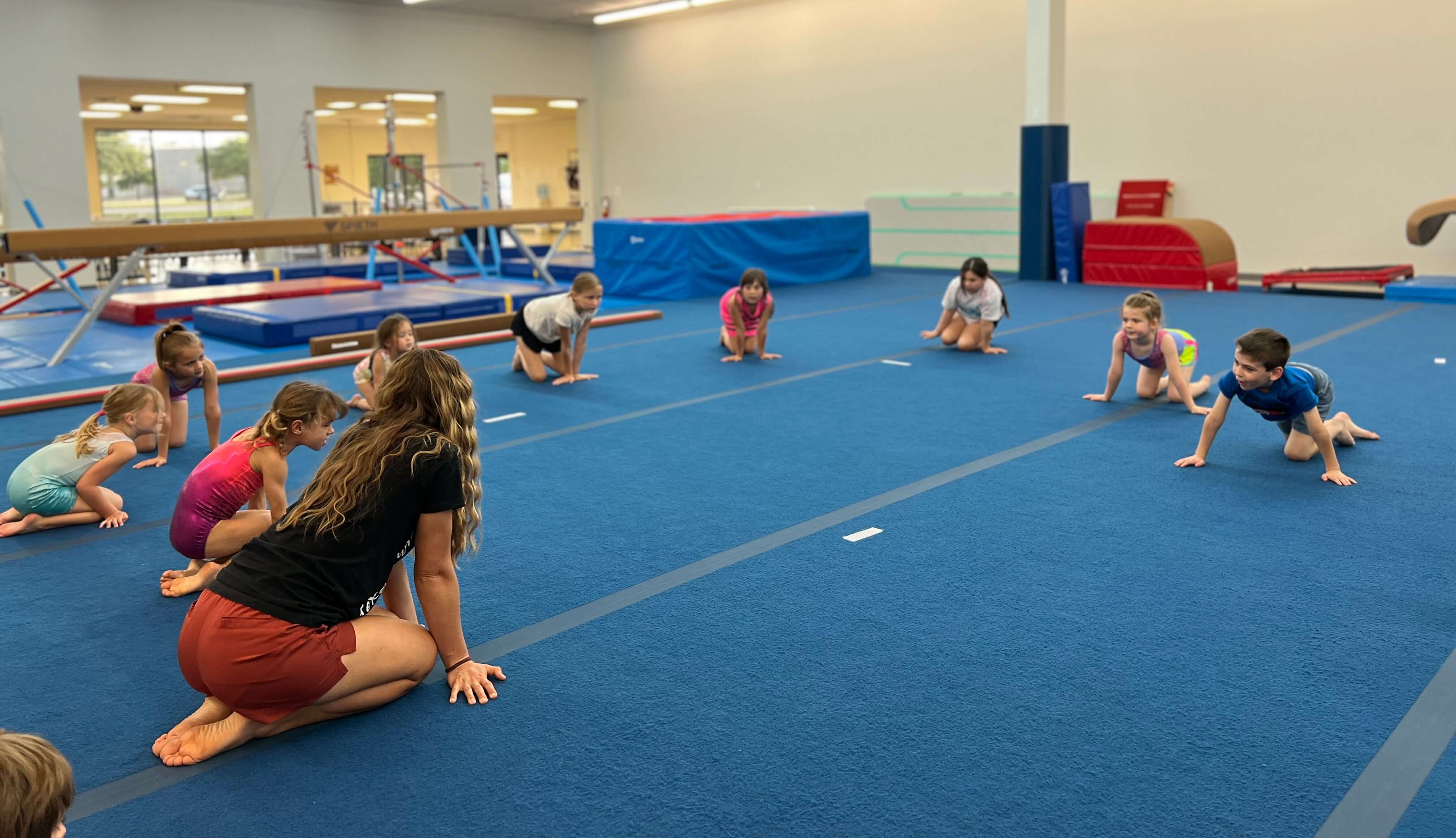 Coach leading kids through a floor warmup
