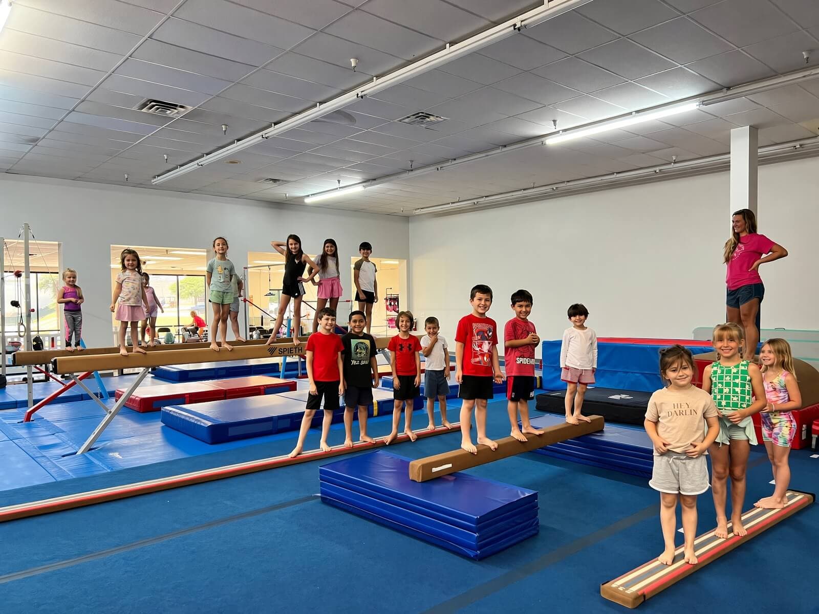 Kids lined up on the balance beams during open gym