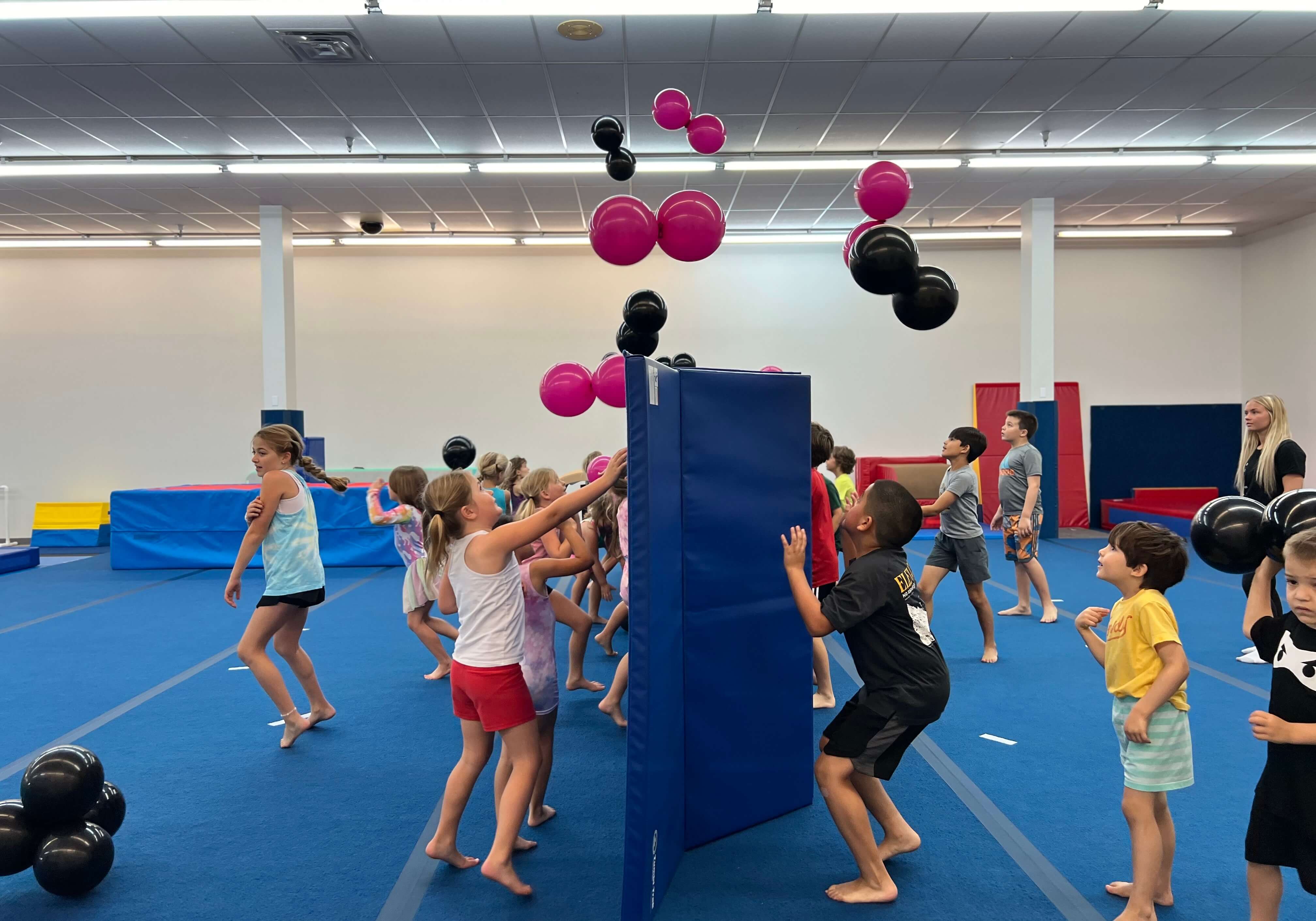 Kids playing a balloon game on the gym floor