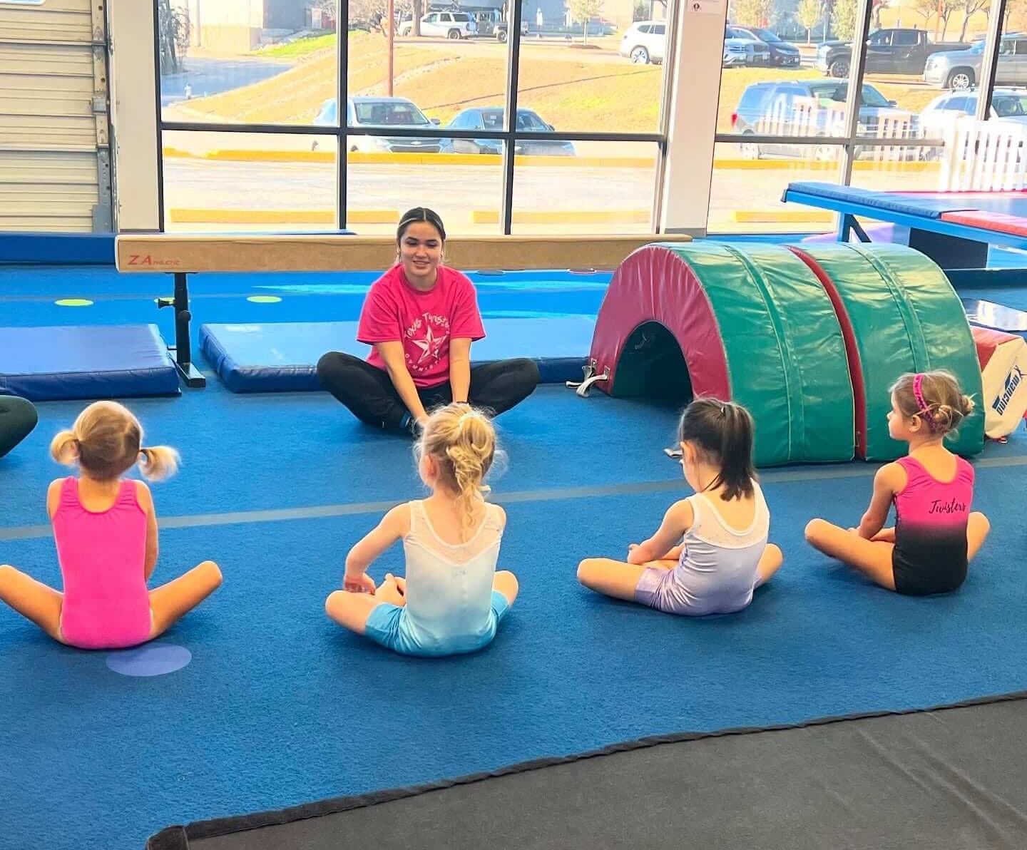 Coach guiding a preschool student on the mats