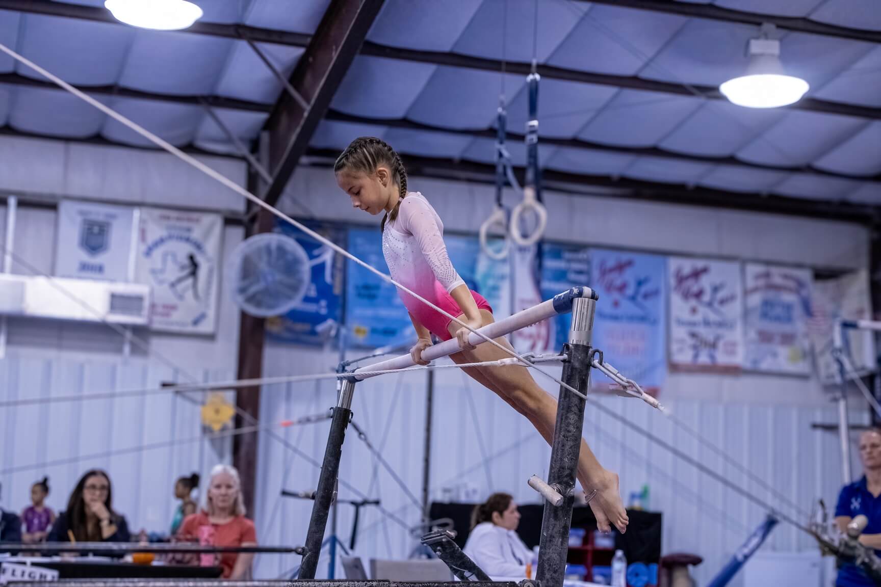 Team gymnast competing on the uneven bars