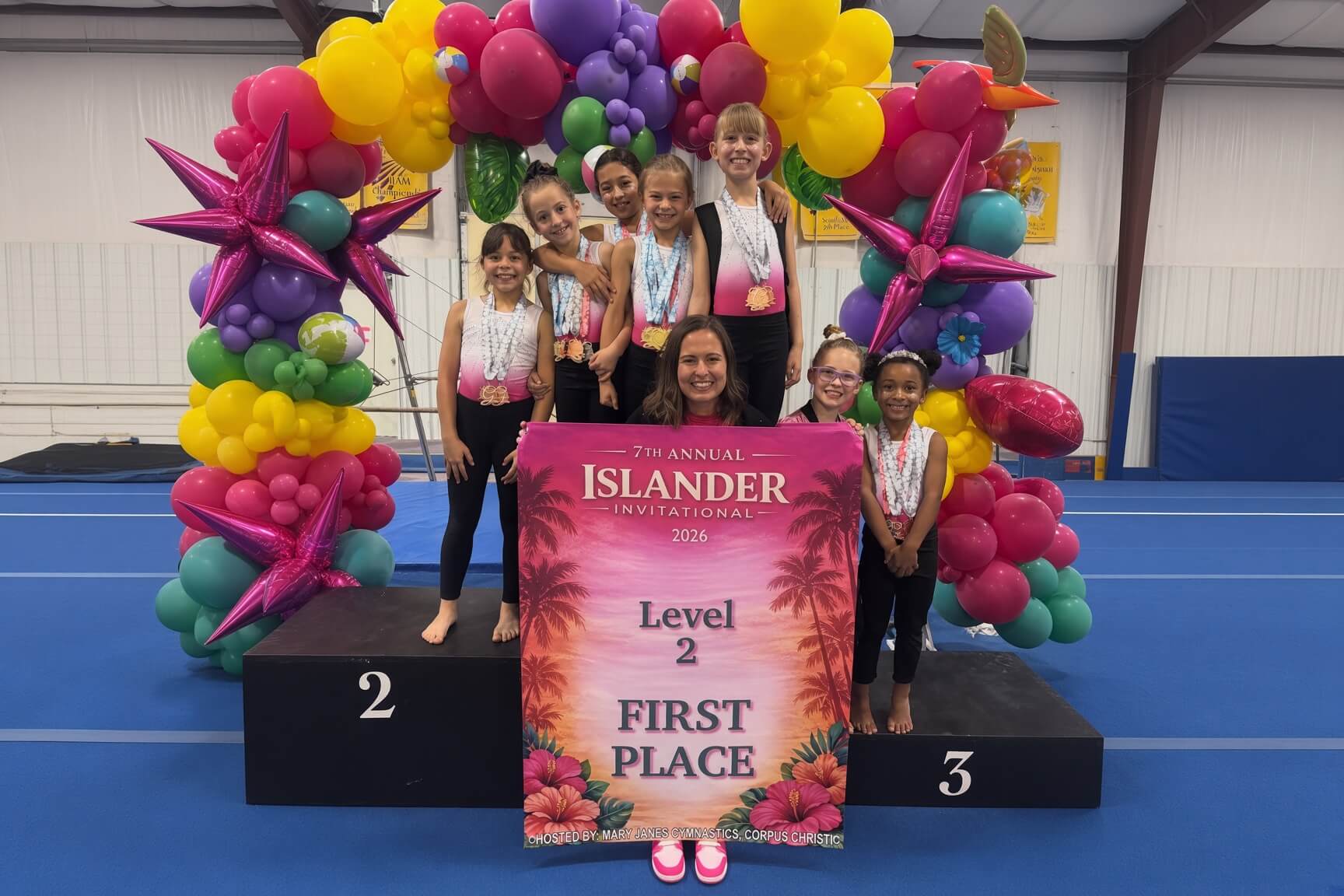 Team gymnasts celebrating first place at the Islander Invitational